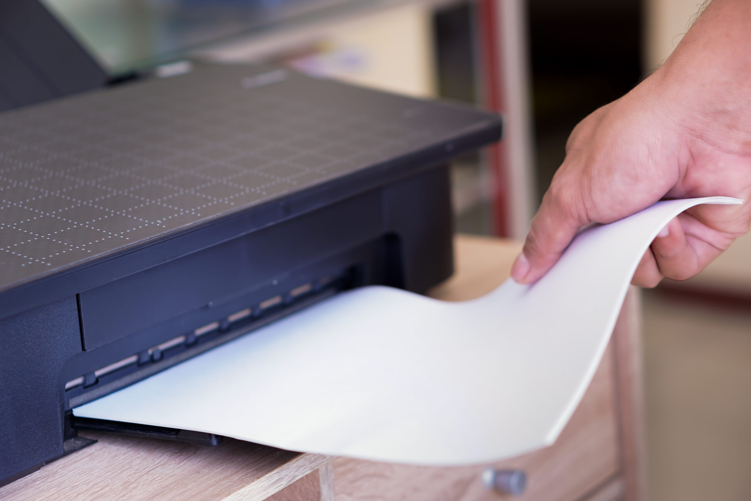 a person taking printed paper from a printer